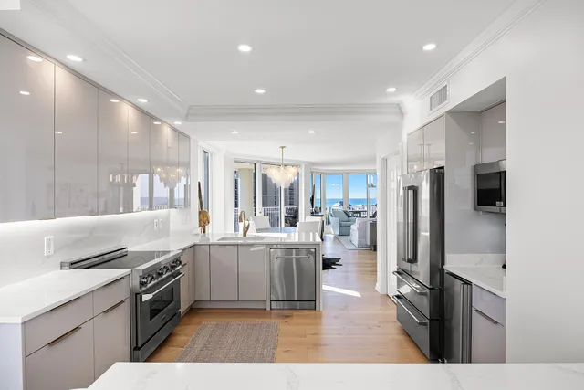 a dining room with wooden floor a chandelier a glass table and chairs