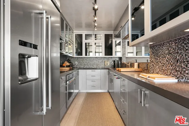 a kitchen with granite countertop cabinets stainless steel appliances and wooden floor