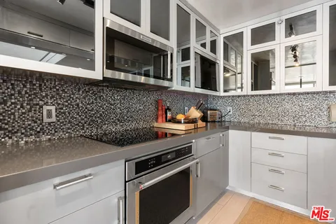a kitchen with stainless steel appliances granite countertop a sink and white cabinets