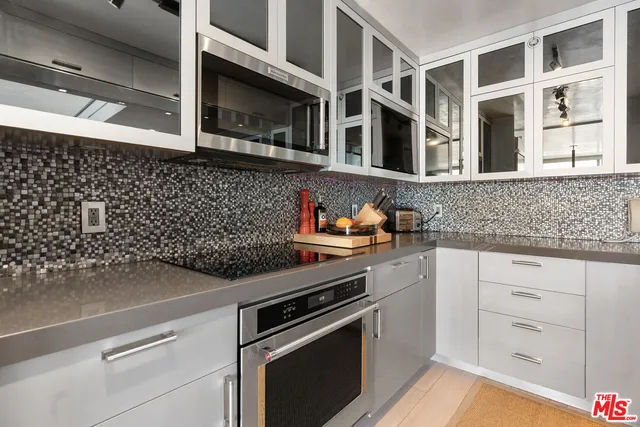 a kitchen with stainless steel appliances granite countertop a sink and white cabinets