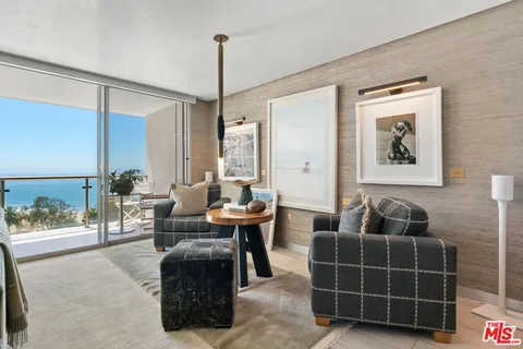 a living room with furniture a wooden floor and next to a window