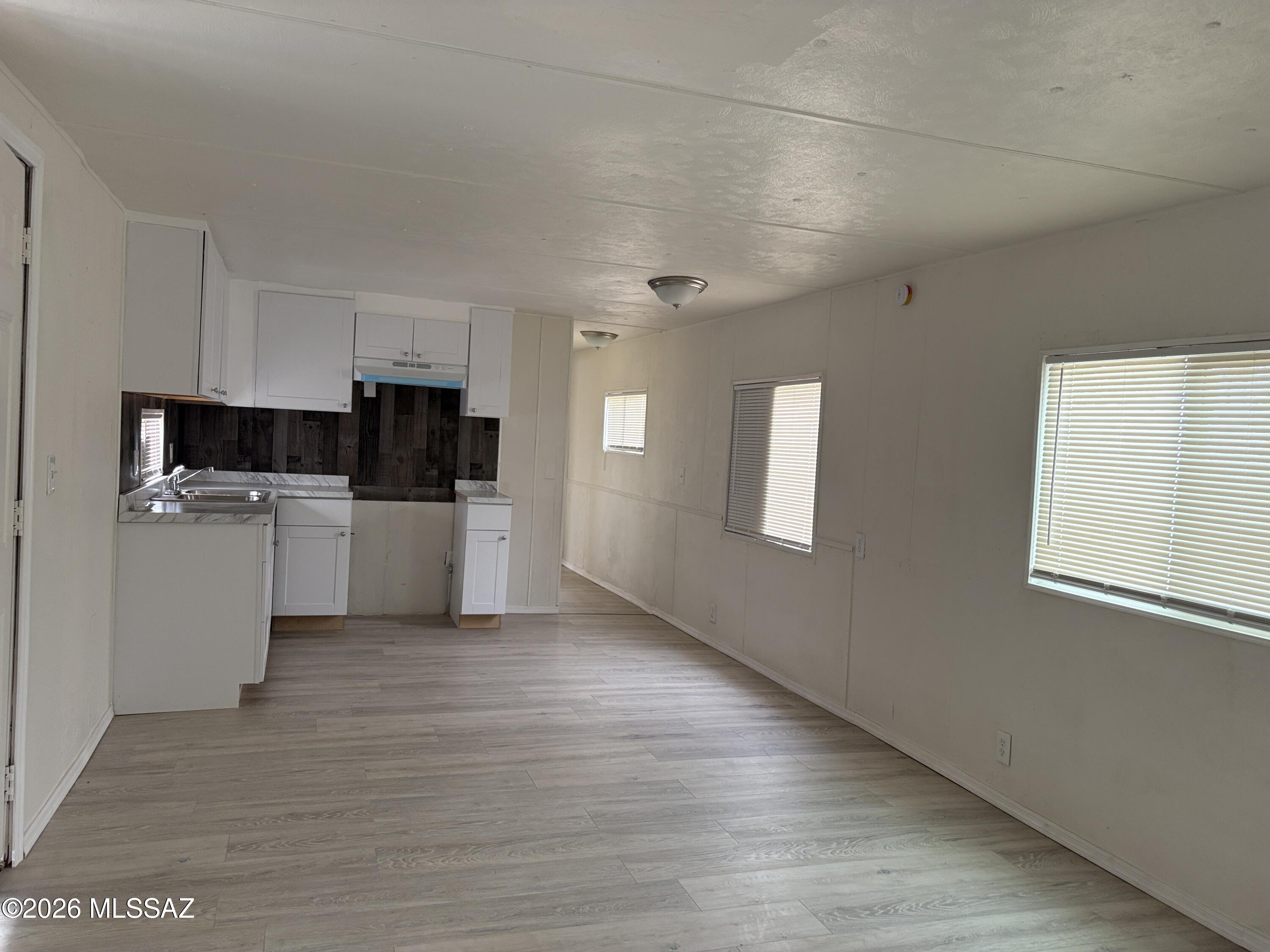 1741 West Wetmore Road, Unit 17 Tucson, AZ 85705 - Photo 5 of 9 a view of a kitchen with wooden floor and electronic appliances