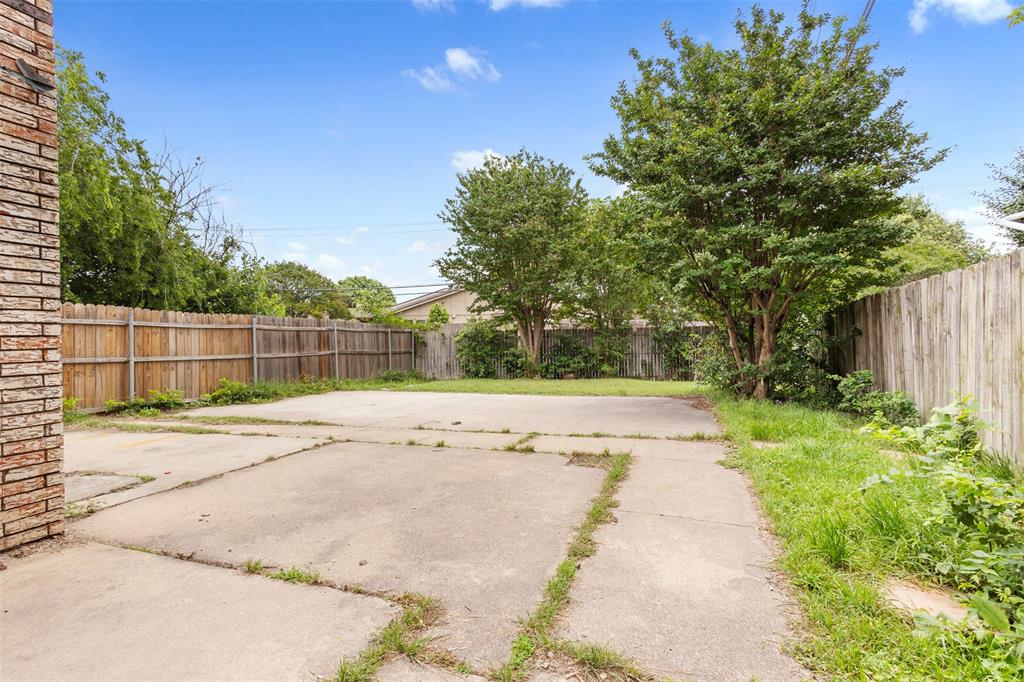 2802 Spring Valley Drive Bedford, TX 76021 - Photo 22 of 24 a view of a yard with plants and trees beside of it