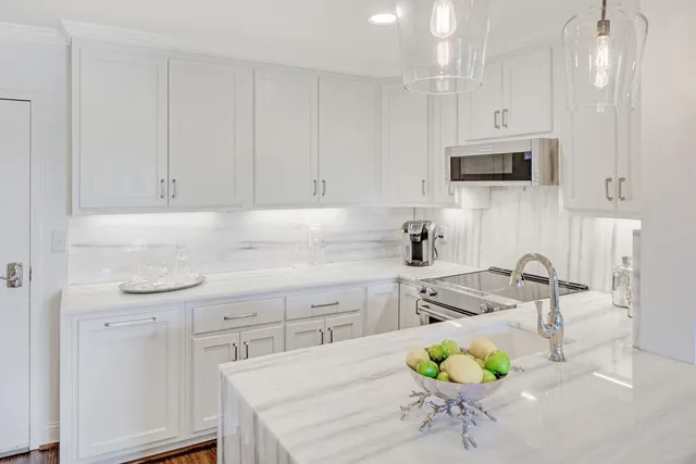 a kitchen with stainless steel appliances a white table chairs and a refrigerator