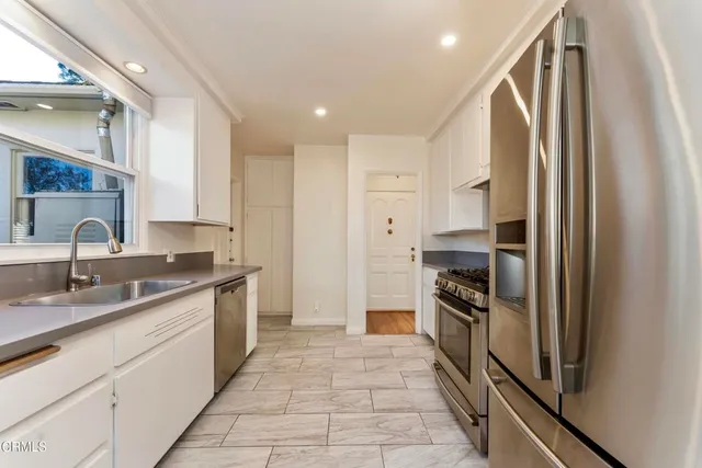 a kitchen with stainless steel appliances granite countertop a refrigerator and a sink
