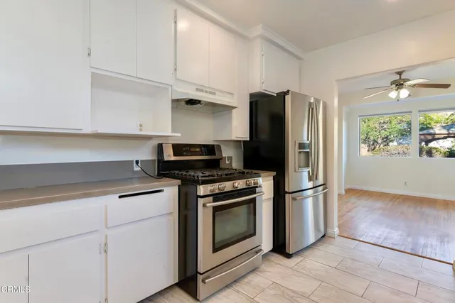 a kitchen with stainless steel appliances white cabinets and a refrigerator