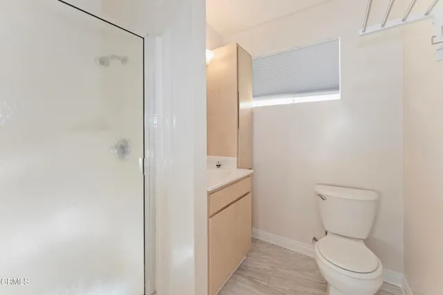 a bathroom with a granite countertop toilet and a shower