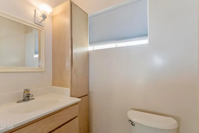 a bathroom with a sink a toilet a mirror and vanity