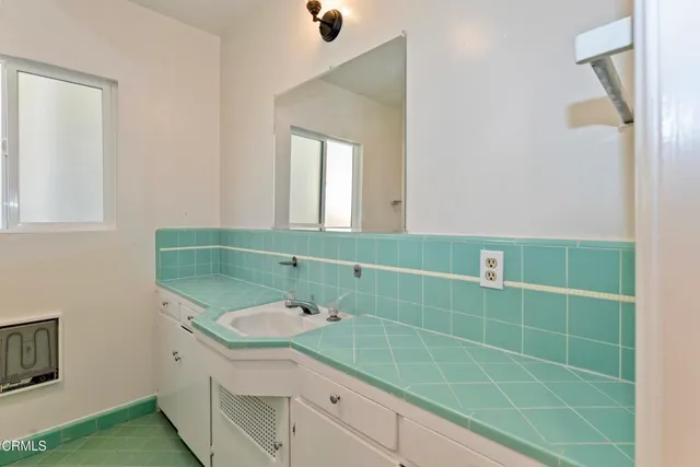 a bathroom with a sink a mirror and a window