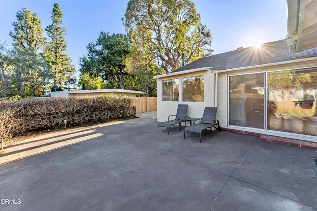 a view of backyard with outdoor seating and a tree