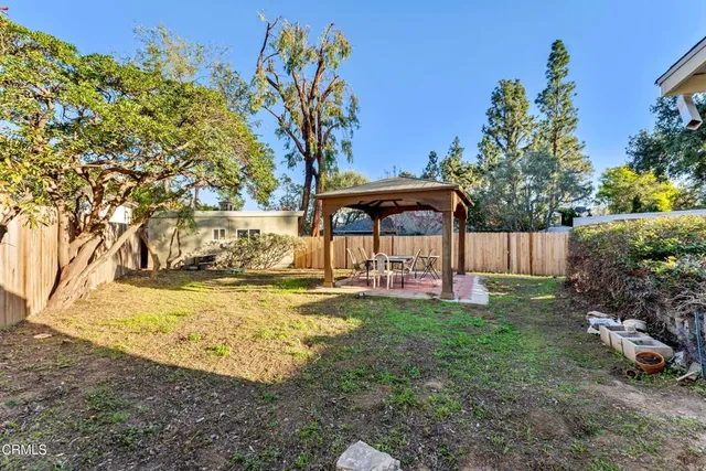 a view of a garden with a table and chair under an umbrella