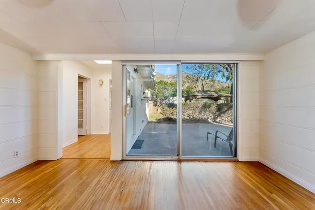 a view of a room with wooden floor and sliding glass door