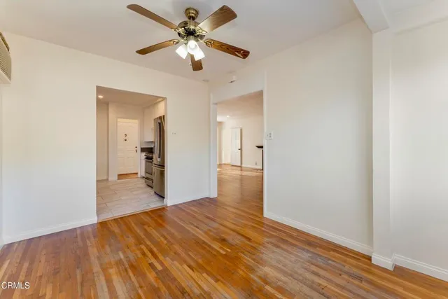 wooden floor in an empty room with a chandelier fan