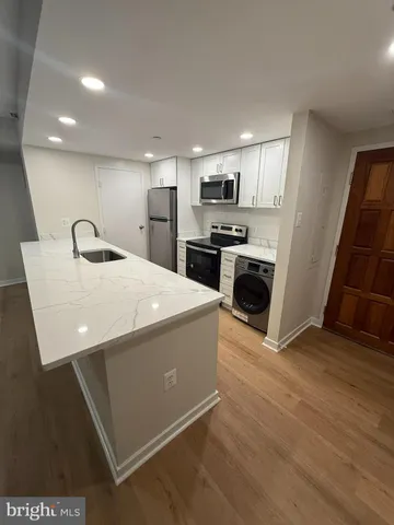 a large kitchen with kitchen island a sink stainless steel appliances and cabinets
