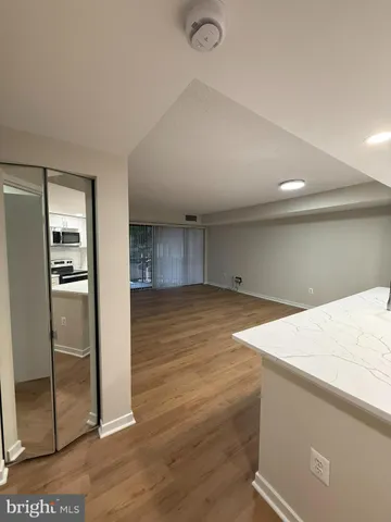 a view of a hallway with wooden floor and glass door