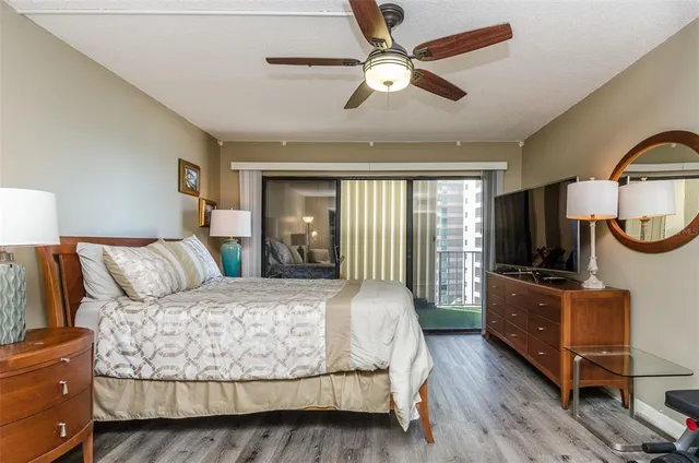 a bedroom with a large bed and a flat tv screen on dresser