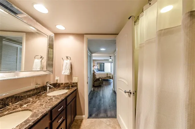 a en suite bathroom with a granite countertop sink and a mirror