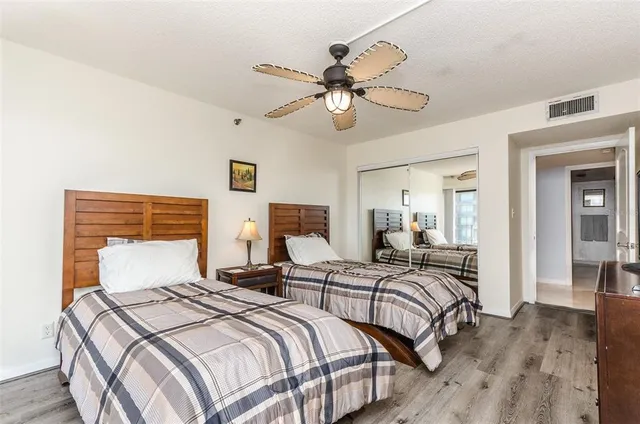 a bedroom with two beds and two mirrors