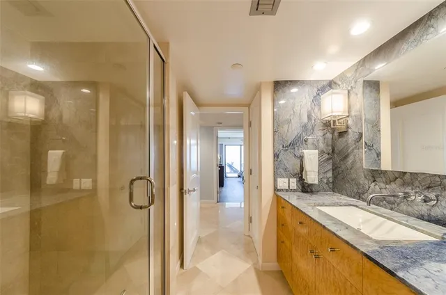 a bathroom with a granite countertop sink mirror and shower