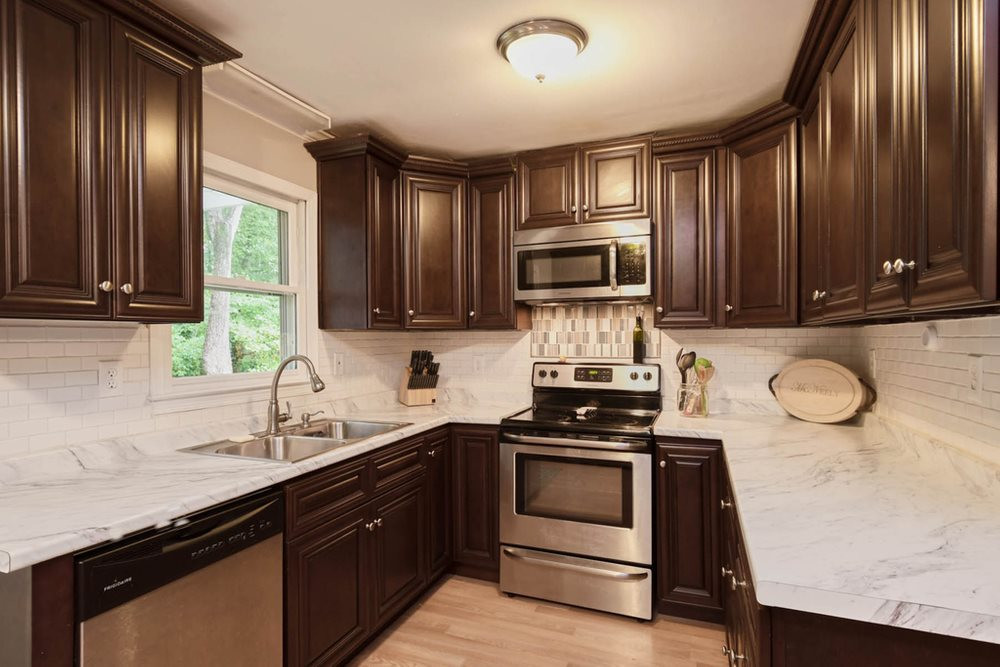 7701 Cresthill Court Raleigh, NC 27615 - Photo 7 of 29 Kitchen features SS appls, tall cabinets for lots of storage, and tile backsplash. Kitchen