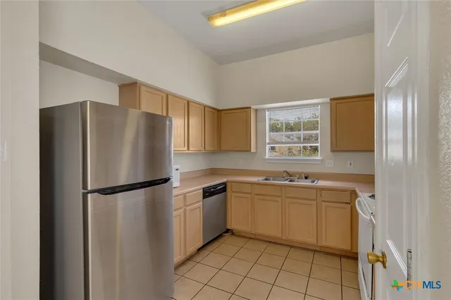 a kitchen with a sink a refrigerator and cabinets