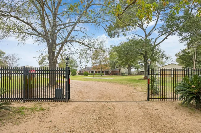 a view of a house with a fence and trees