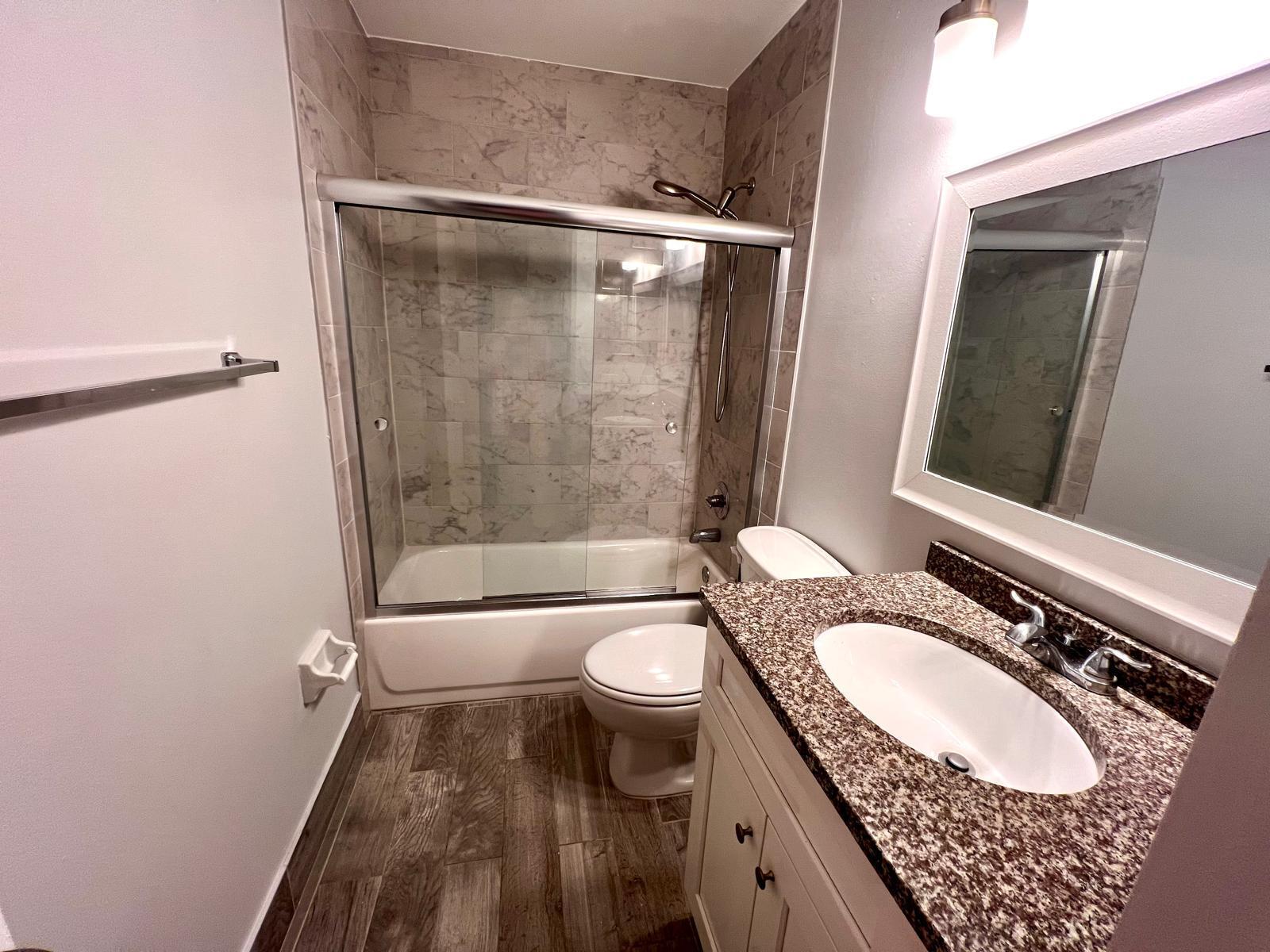 8113 Ambach Way, Unit 28A Hypoluxo, FL 33462 - Photo 11 of 20 a bathroom with a granite countertop sink toilet and shower
