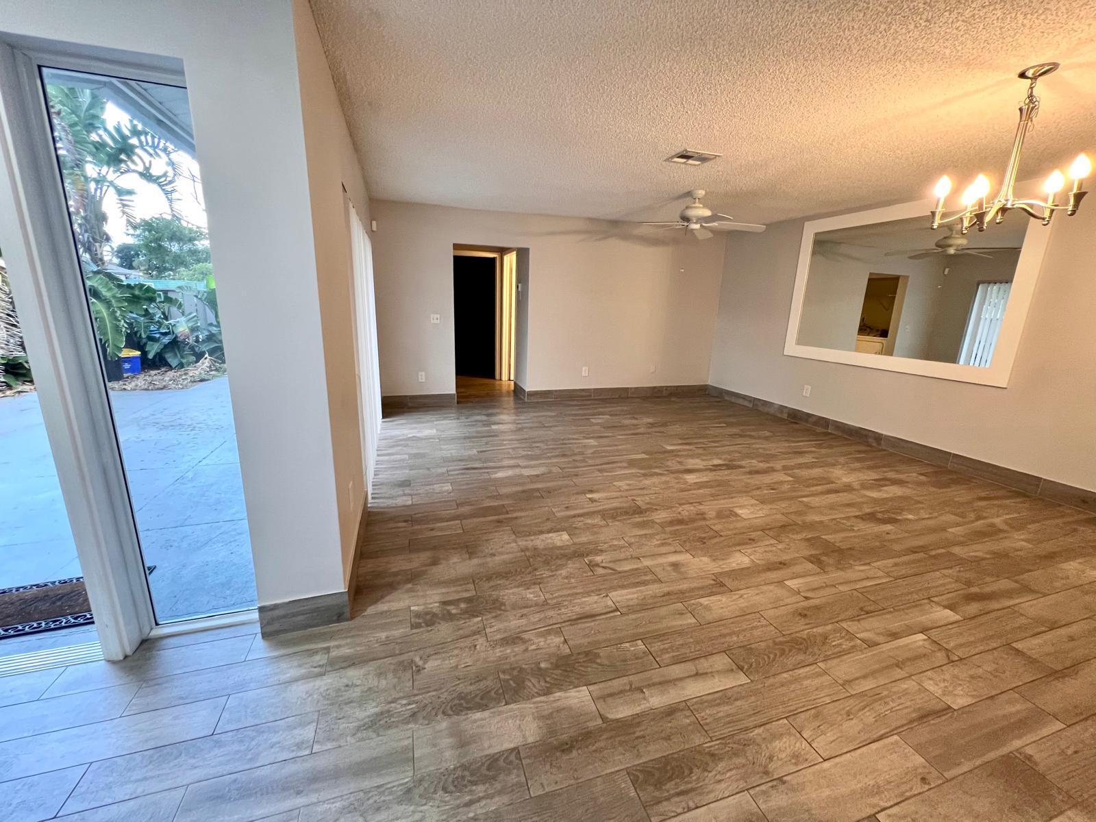 8113 Ambach Way, Unit 28A Hypoluxo, FL 33462 - Photo 5 of 20 an empty room with wooden floor and windows