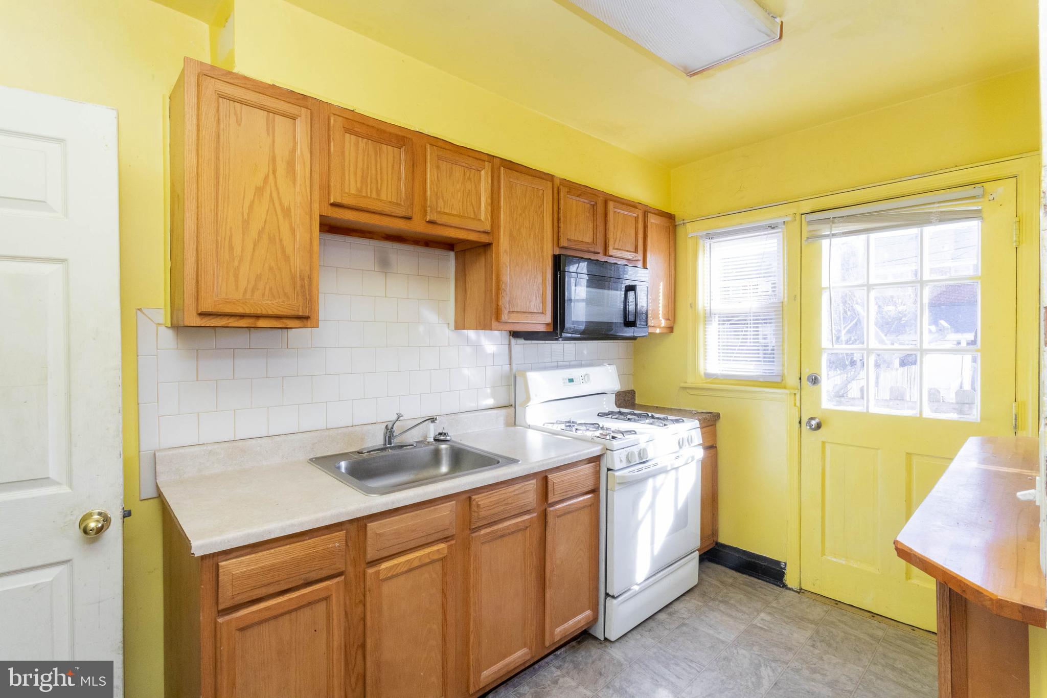 1919 Larkhall Road Dundalk, MD 21222 - Photo 12 of 23 a kitchen with stainless steel appliances granite countertop a sink a stove and a refrigerator