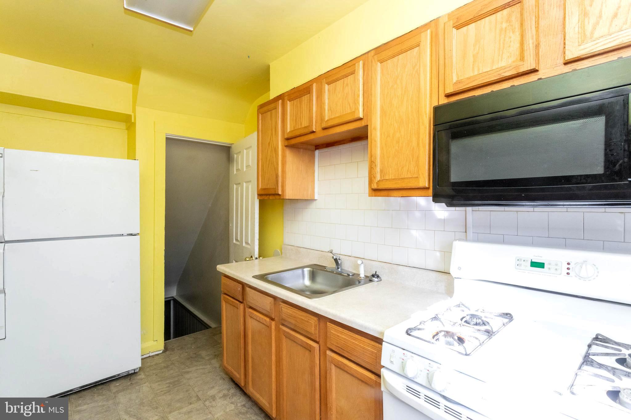 1919 Larkhall Road Dundalk, MD 21222 - Photo 10 of 23 a kitchen with stainless steel appliances a stove a microwave and a refrigerator