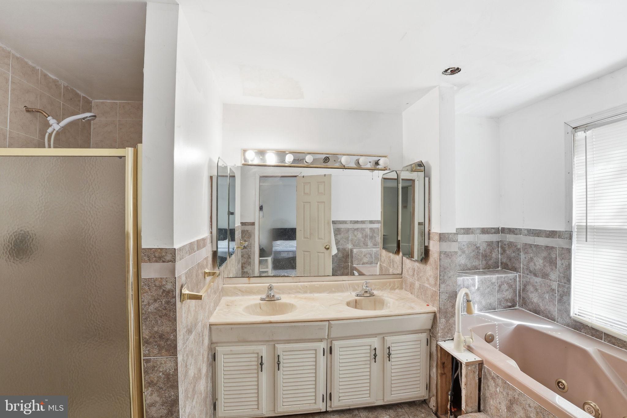 17107 Overhill Road Rockville, MD 20855 - Photo 20 of 37 a bathroom with a sink double vanity and a bathtub