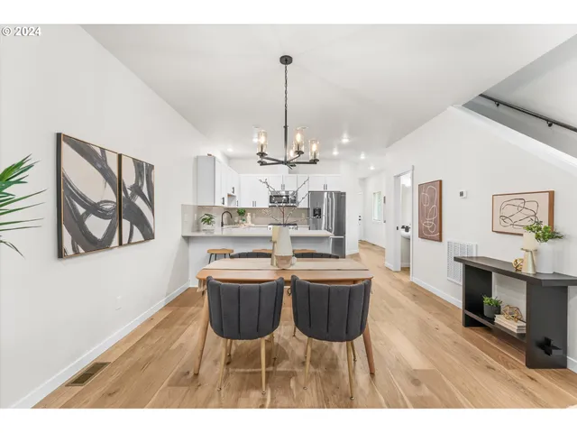 a view of a dining room with furniture a chandelier and wooden floor