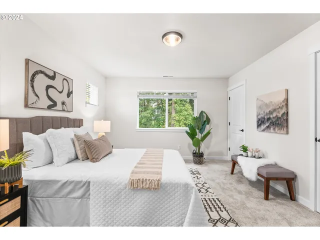 a bedroom with a large bed and a potted plant