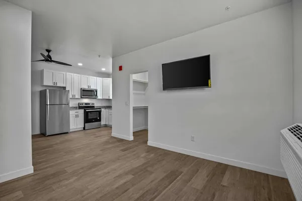 a view of kitchen with stainless steel appliances with wooden floor