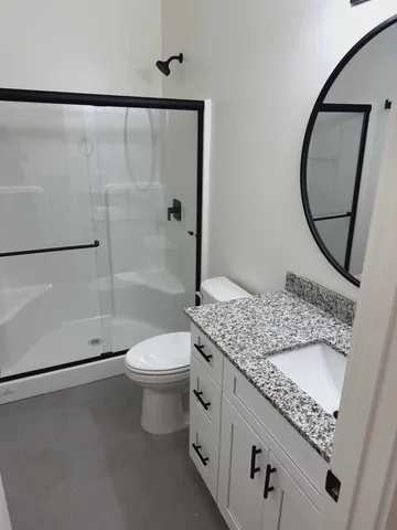 a bathroom with a granite countertop sink toilet and shower