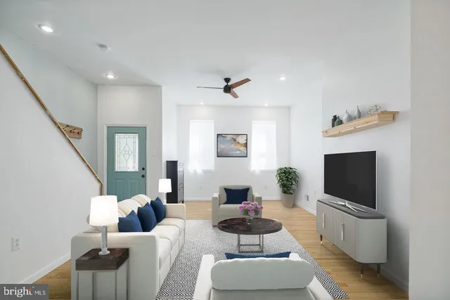 a living room with furniture a flat screen tv and a window