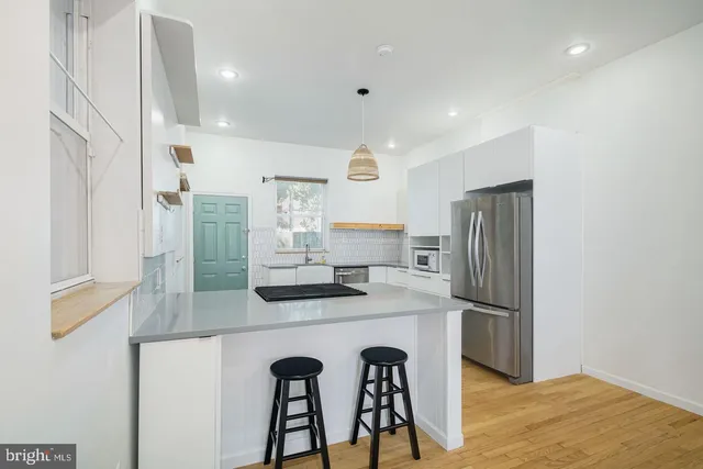 a kitchen with stainless steel appliances granite countertop a refrigerator and a stove top oven