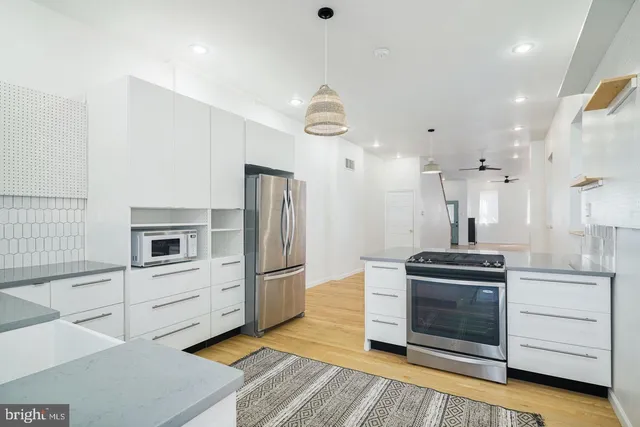 a kitchen with granite countertop a refrigerator and a stove top oven
