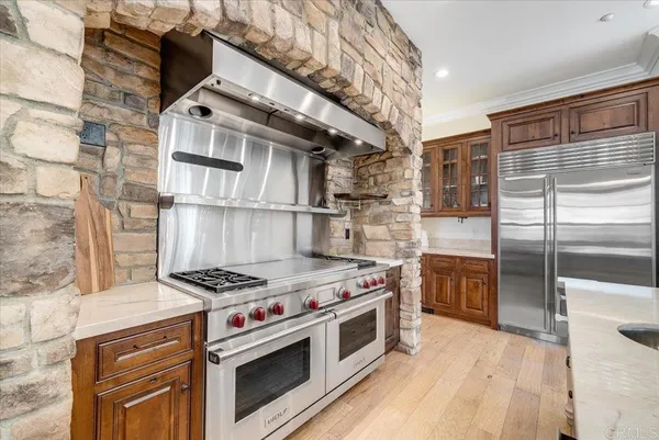 a large white kitchen with stainless steel appliances kitchen island granite countertop a refrigerator and a sink