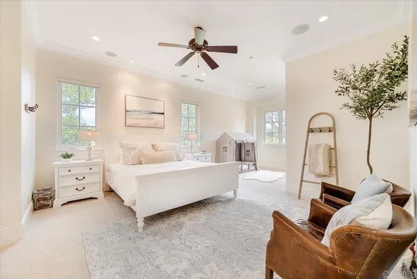 a spacious bedroom with a large bed and a chandelier