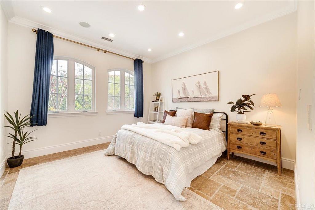 32110 Dos Ninas Bonsall, CA 92003 - Photo 31 of 75 a spacious bedroom with a large bed and a chandelier