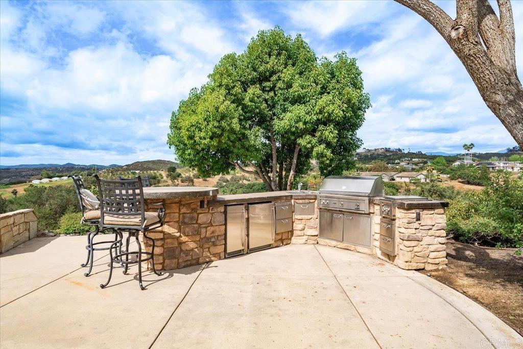 32110 Dos Ninas Bonsall, CA 92003 - Photo 54 of 75 a view of a patio with table and chairs with wooden floor and fence