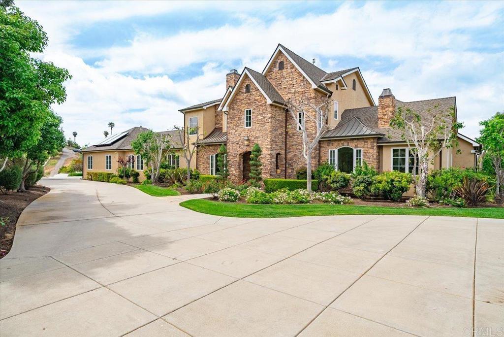 32110 Dos Ninas Bonsall, CA 92003 - Photo 59 of 75 a view of a white house with a yard and potted plants