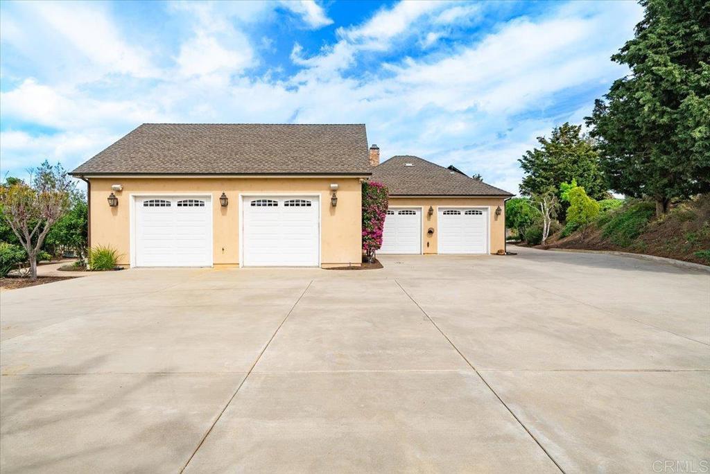 32110 Dos Ninas Bonsall, CA 92003 - Photo 60 of 75 a front view of a house with a yard and garage