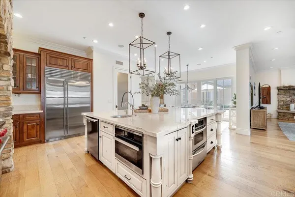 a large white kitchen with a large island in the center