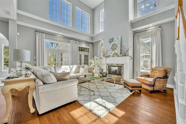 a living room with furniture kitchen view and a chandelier