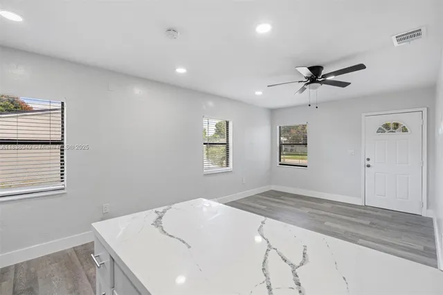 a bedroom with a large bed and a chandelier fan