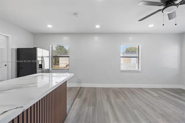 a view of kitchen island wooden floor window and refrigerator