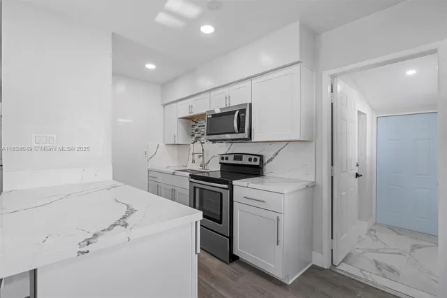 a view of a kitchen with stove top oven and cabinets