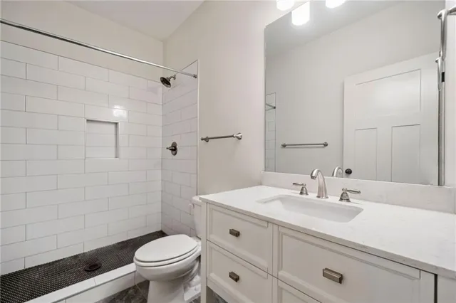 a kitchen with stainless steel appliances granite countertop a stove a sink dishwasher and a refrigerator with wooden floors